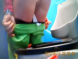 Woman in green pants pissing