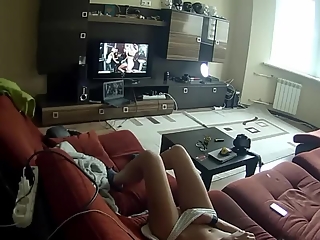 Chick masturbating in the couch while watching porn