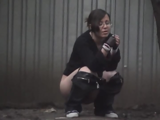 Girl in glasses caught peeing outdoors