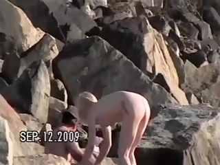 Small tits nudist at rocky beach