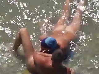 Woman blows her man's cock in the water