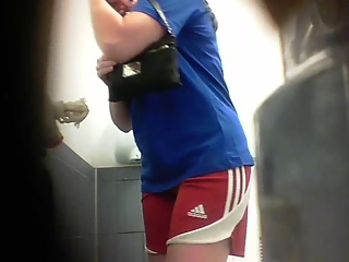 Woman in blue t-shirt and red sports peeing