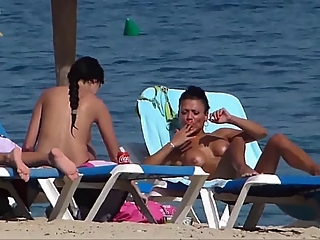 Pretty topless girls sunbathing on the beach