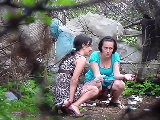 Two brunette women spied pissing outdoors