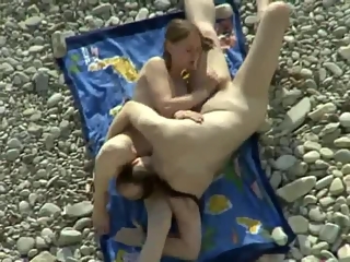 Nudist couple making 69 in the rocky beach