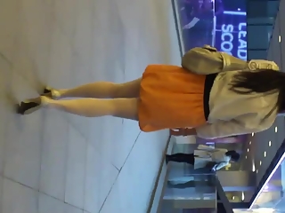 Woman in orange skirt upskirted