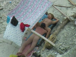 Nudist couple spied on beach.