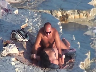 Nude couple fucking at rocky beach